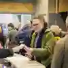 A man collects an accreditation badge from the reception desk a a conference