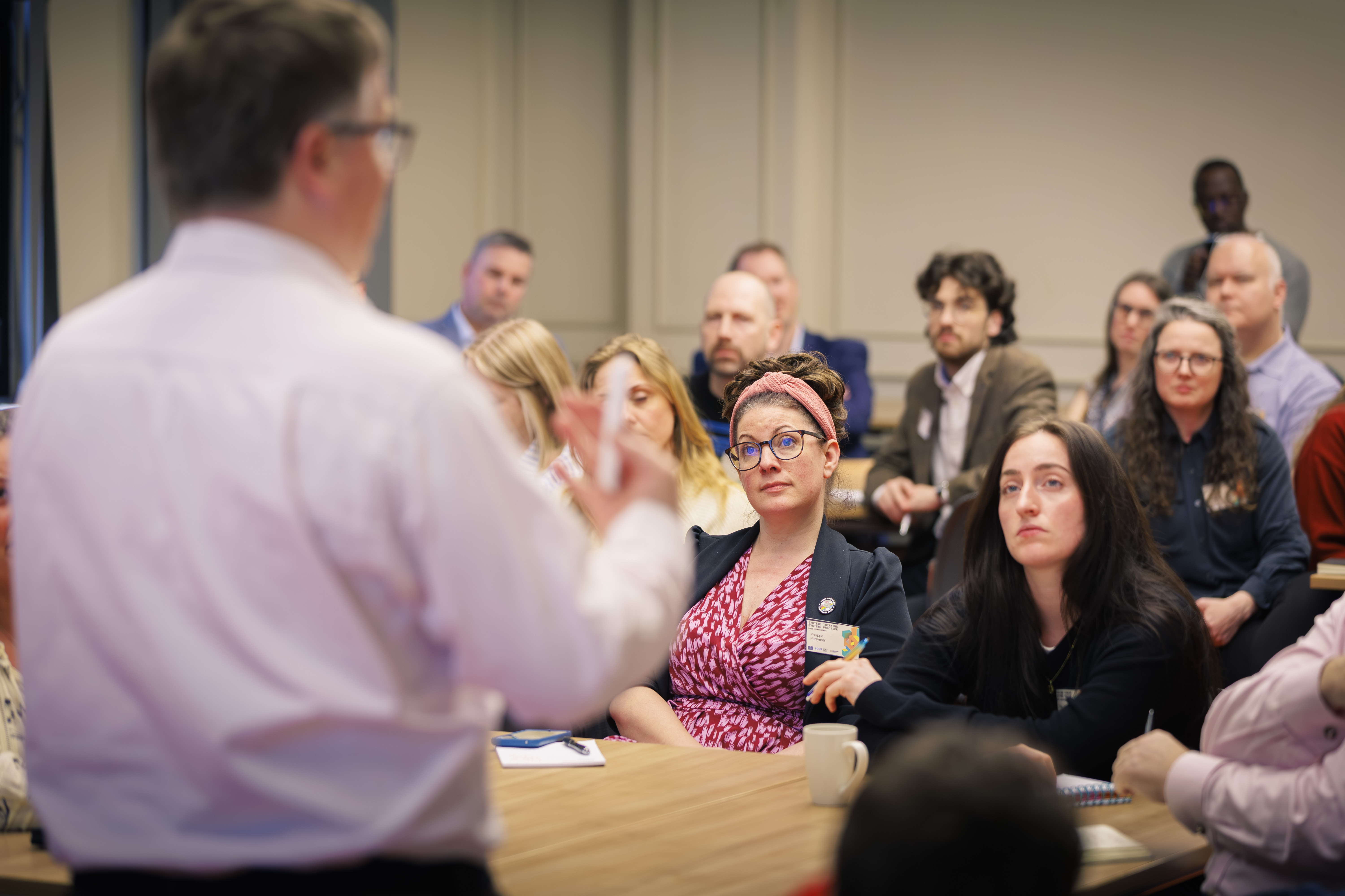 A group of conference attendees listen to a speaker