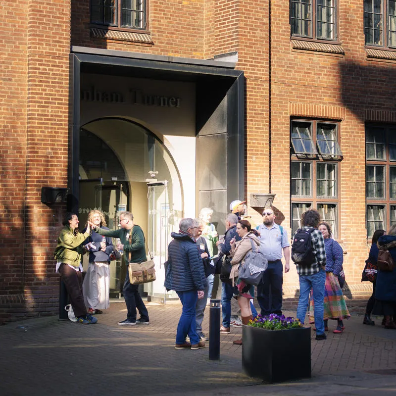 Conference attendees chat and network outside Canham Turner