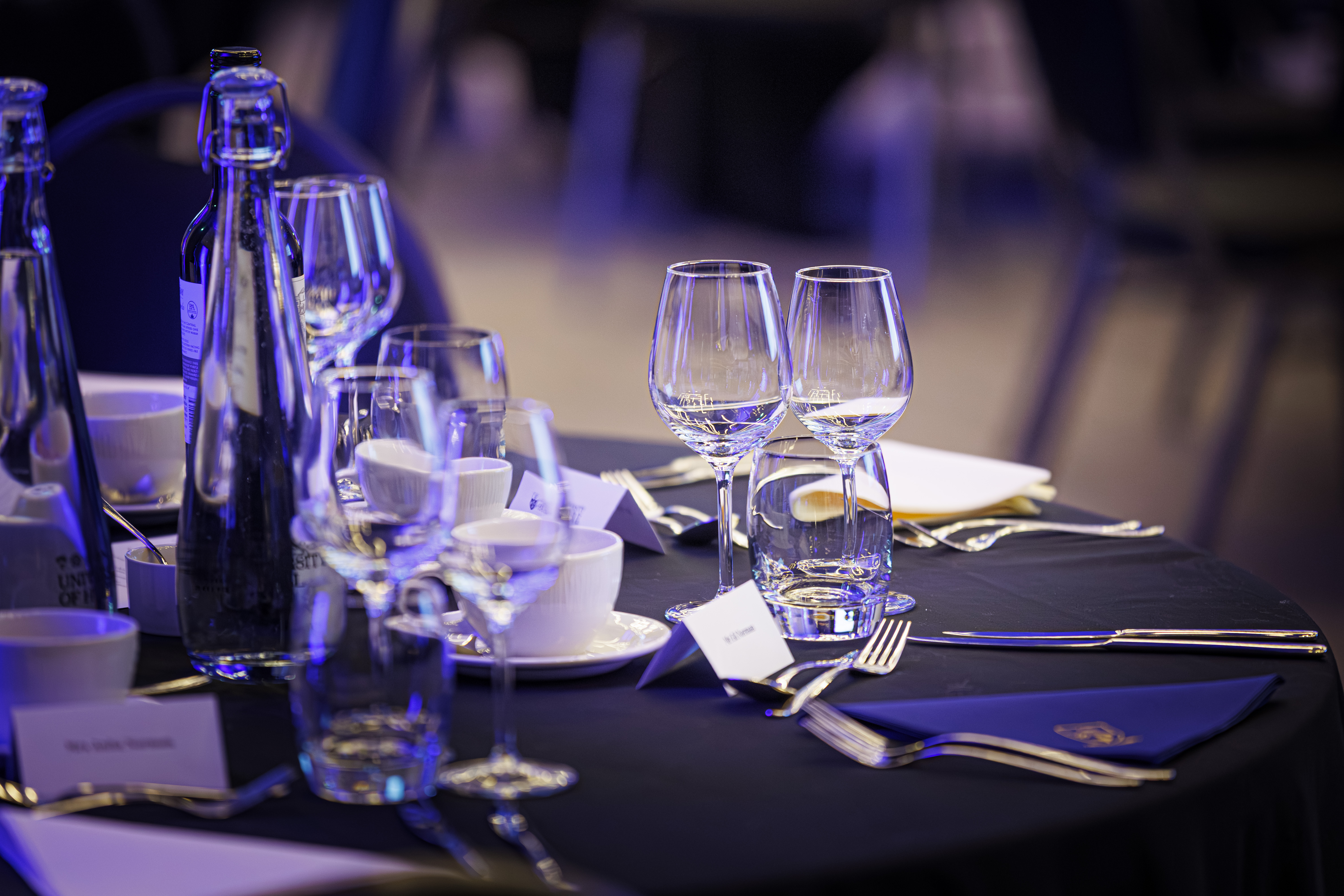 A close up of glasses and dinnerware at a set table