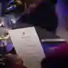 A woman examines a menu while wine is poured into her glass