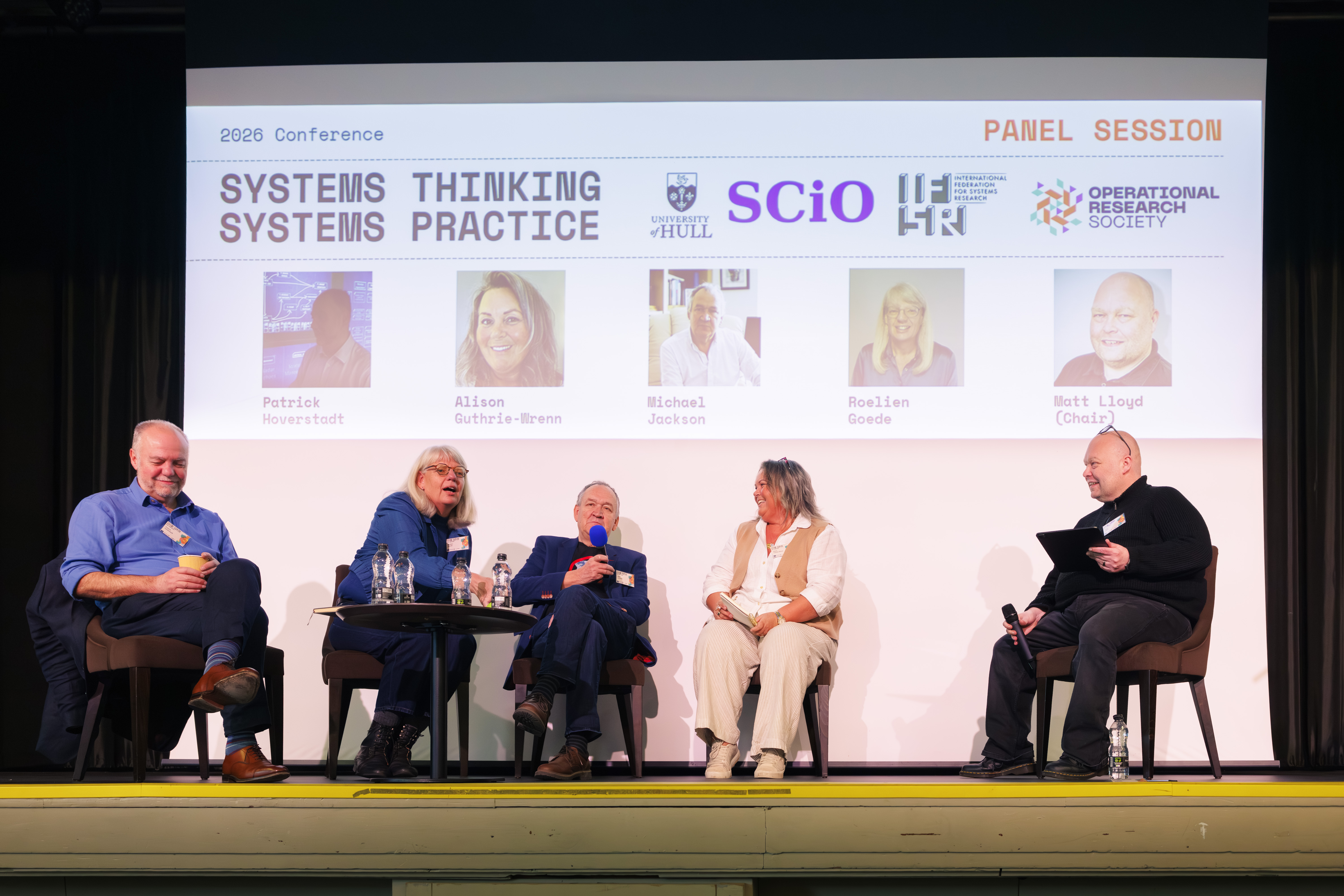 A panel discussion takes place on stage with four participants and a facilitator