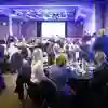 People sit around tables at a formal dining event