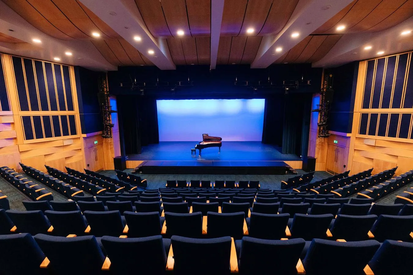 A large auditorium including a stage with a piano