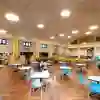 A handful of people sit in a large dining room