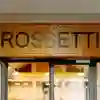 A close up of the word 'Rossetti' over the doors to the dining hall