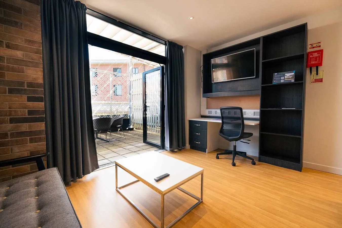 Large lounge with sofa, coffee table, desk and TV.