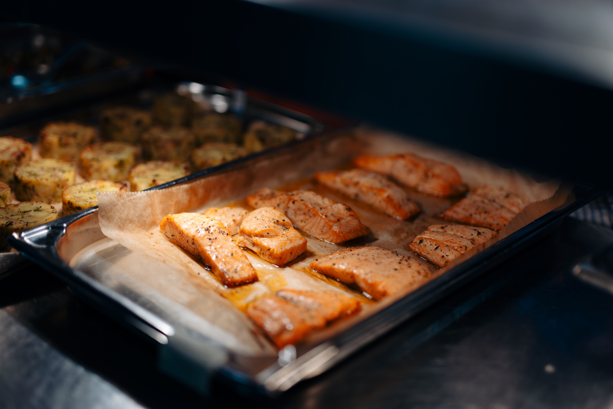 Rows of salmon fillets baking on a tray