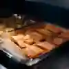 Rows of salmon fillets baking on a tray
