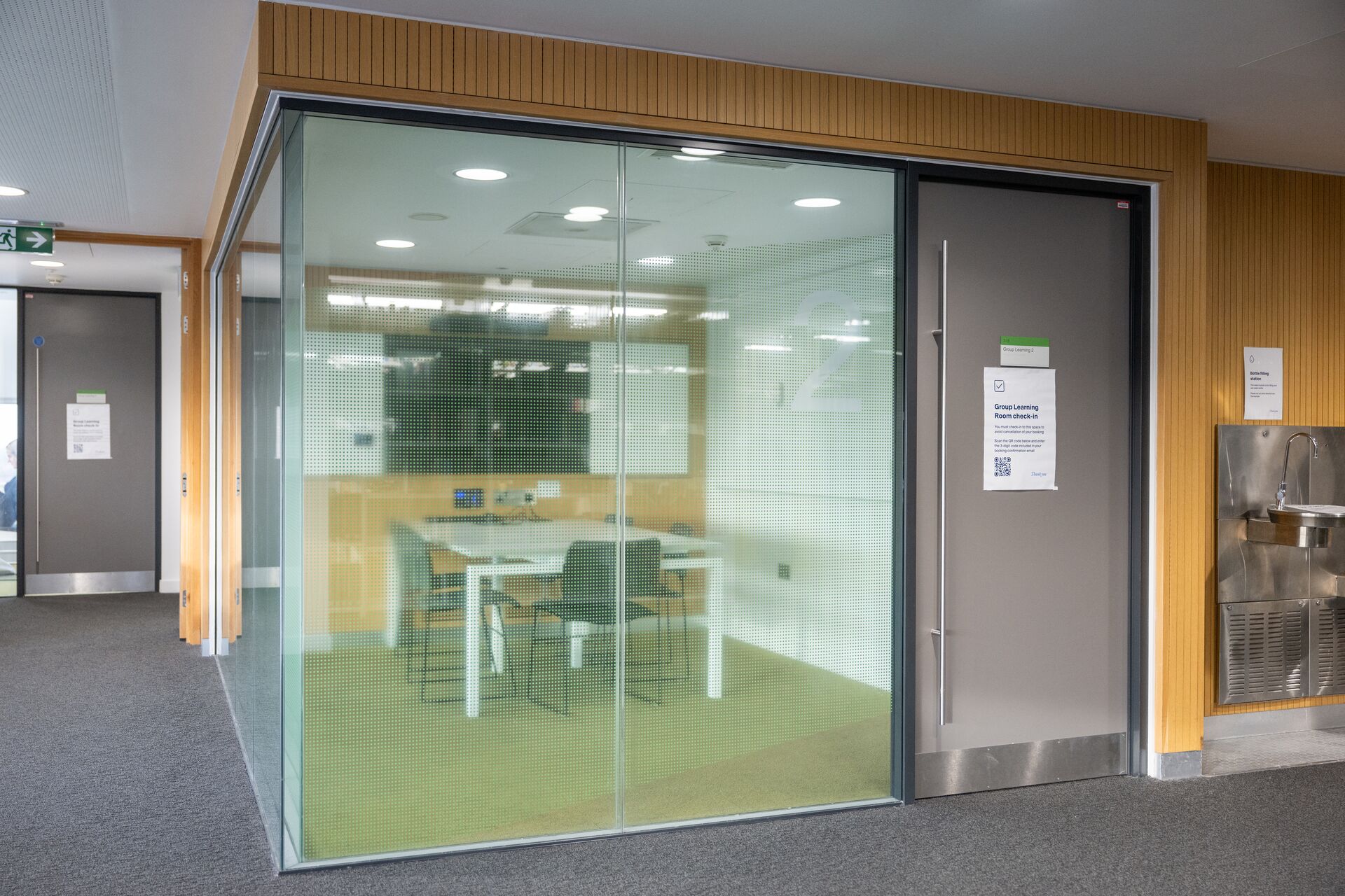 A small enclosed group study room with glass walls