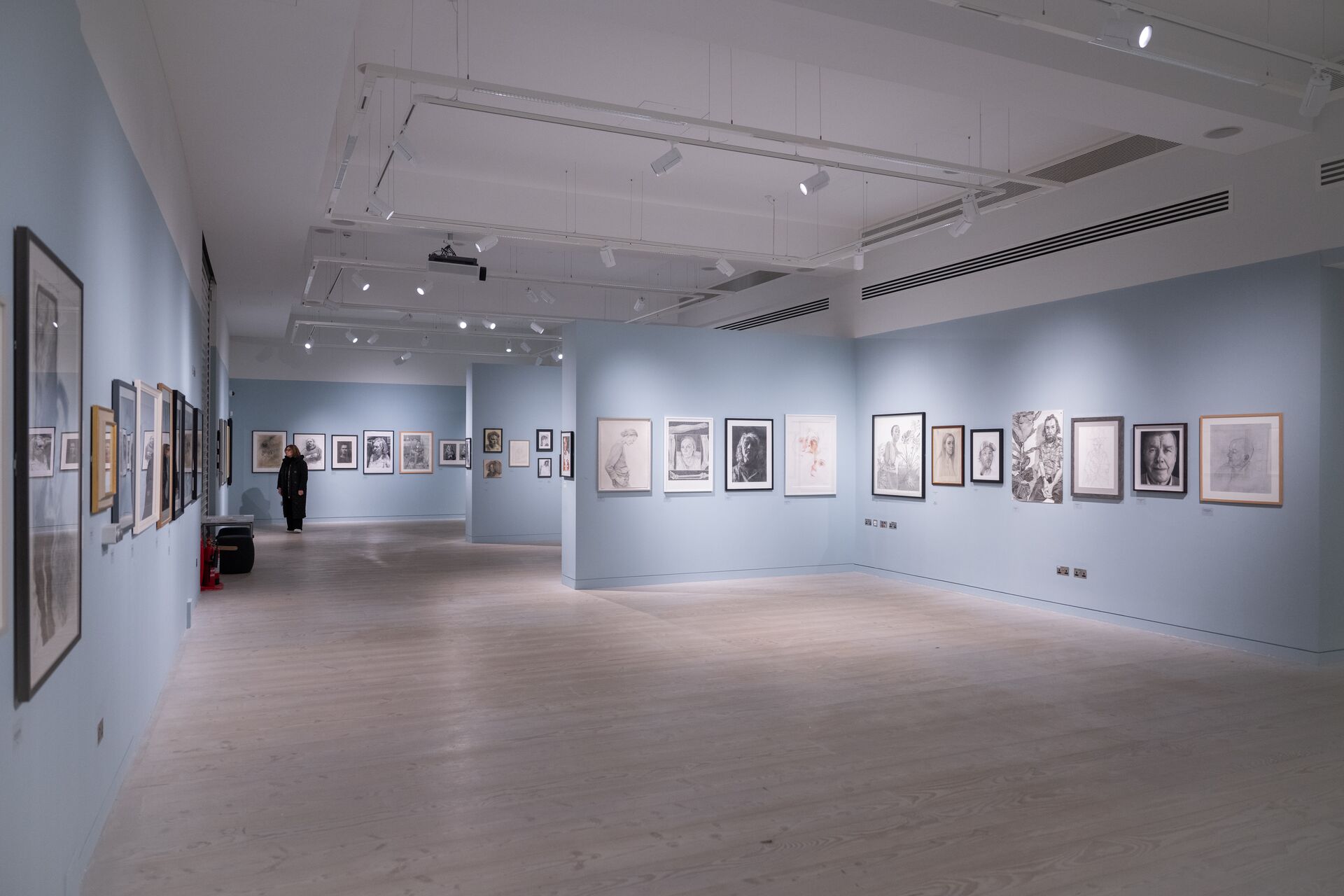 A large exhibition space with portraits on the walls