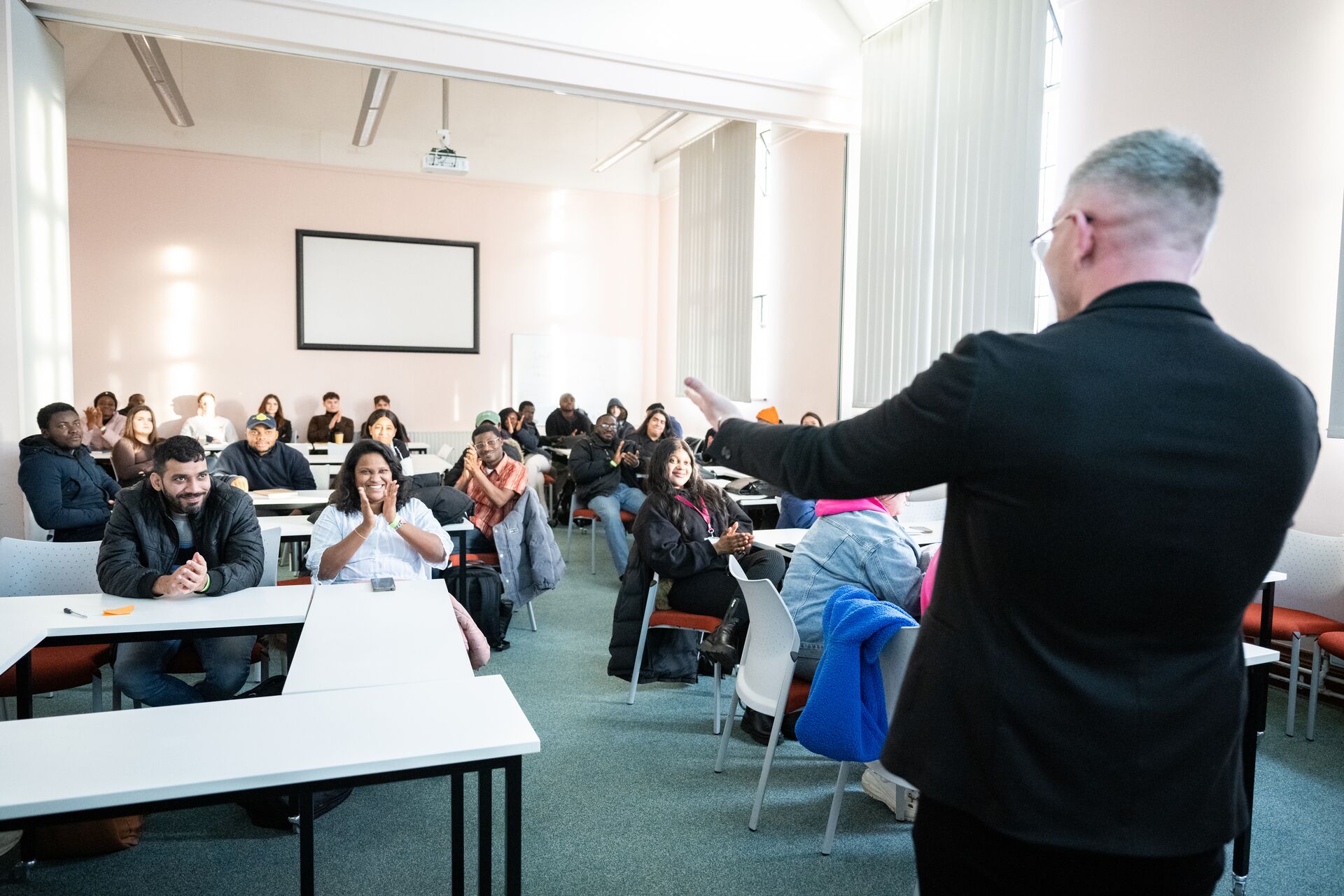 A man gives in a talk in a room with movable furniture