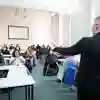 A man gives in a talk in a room with movable furniture