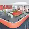 An aerial view of a large, open-plan breakout space in the Allam Medical Building with bright orange furntiure